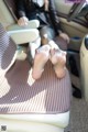 A woman sitting in the back seat of a car with her feet up.