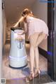 A woman in a pink dress standing next to a vending machine.