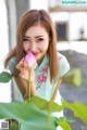 A woman holding a pink lotus flower in her hand.