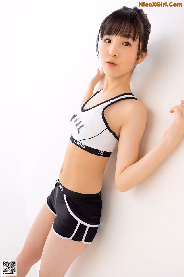 A woman in a black and white sports bra top and shorts.
