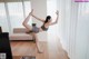 A woman doing a yoga pose in front of a television.