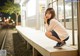 A woman sitting on a bench at a train station.