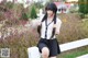 A woman sitting on top of a white fence.