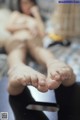 A woman laying on top of a bed with her feet up.