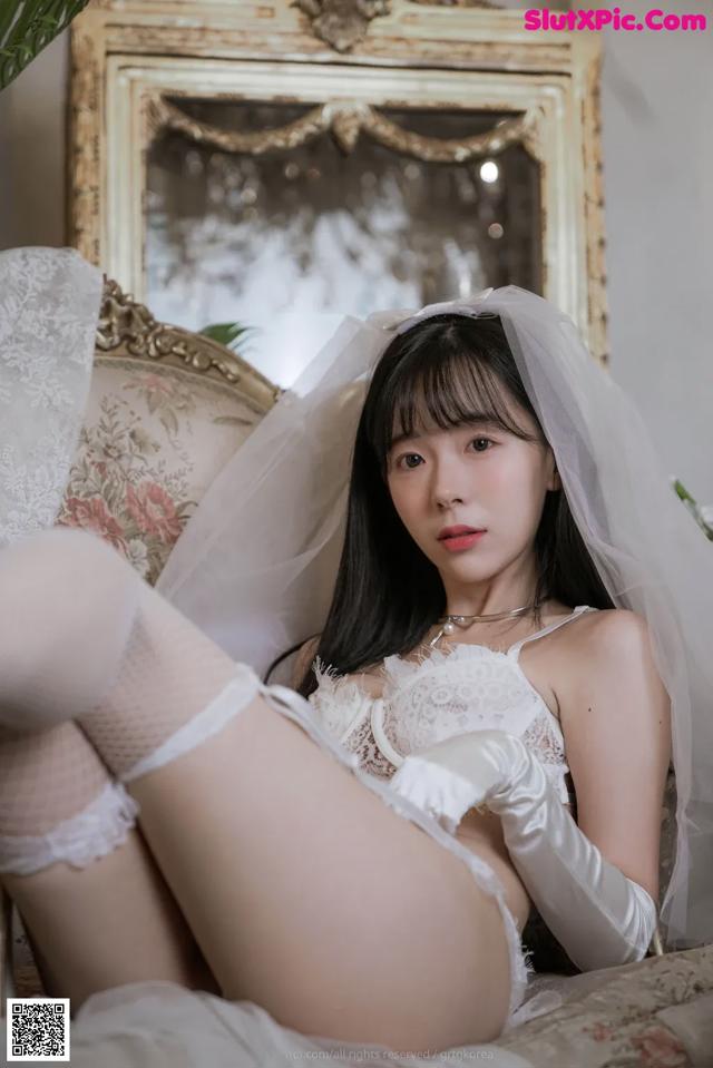 A woman in a wedding dress sitting on a couch.