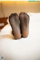 A pair of black stockings sitting on top of a bed.