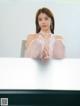 A woman sitting on top of a white table.