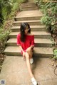 A woman sitting on the steps of a set of stairs.