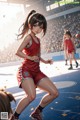 A woman in a red uniform is playing basketball.