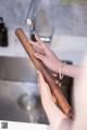 A woman is washing her hands under a faucet.