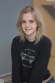 A young woman wearing a black sweatshirt with a skateboard on it.