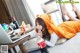 A woman laying on a bed with a laptop and a bottle of soda.